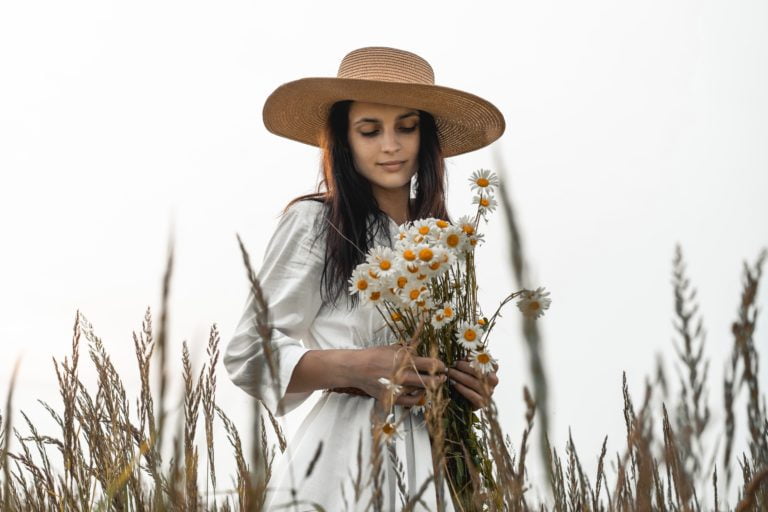 Woman holding Daisies in hay field - Happy and peaceful